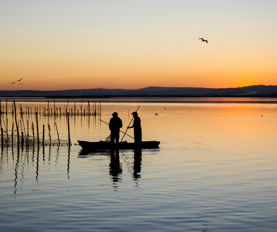 albufera valencia paella tramonto uomini in barca
